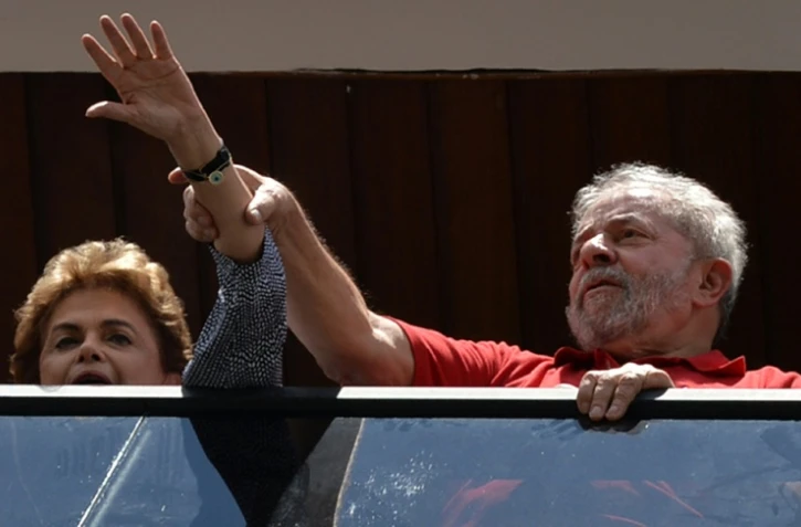 L'ancien président brésilien Lula da Silva (d) et la présidente en exercice Dilma Rousseff saluent leurs partisans le 5 mars 2016 à Sao Paulo