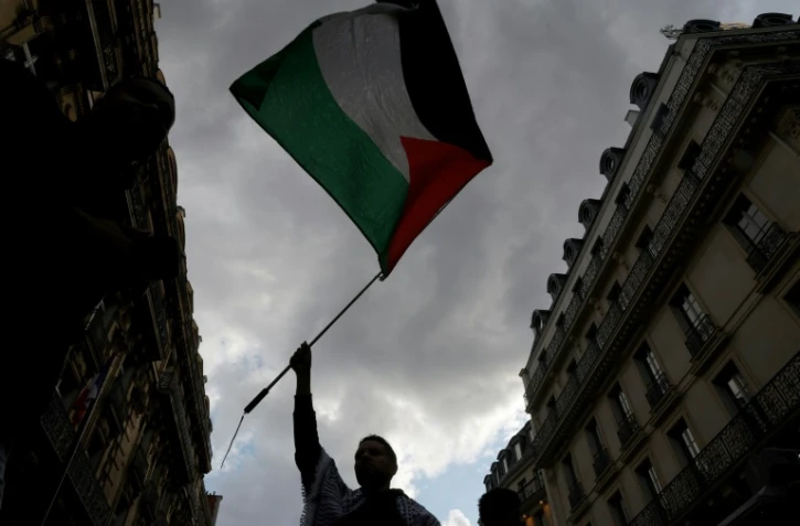 Un manifestant brandit un drapeau palestinien lors d'une rassemblement organisé par l'organisation française "France Palestine Solidarité" à Paris, le 27 mai 2024