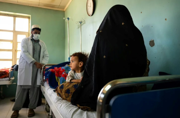 Un docteur parle à une patiente venue avec son enfant à la clinique de Tangi Saidan, le 6 octobre 2021 en Afghanistan