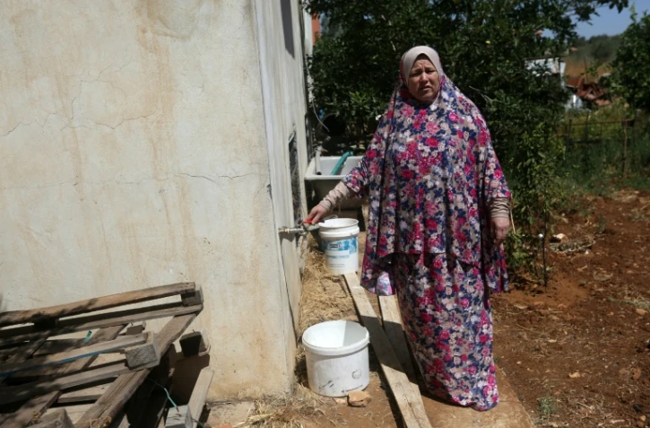 Fatma Ali, montre la fontaine de son jardin d'où aucune eau ne coule, dans son village de Salfit (nord de la Cisjordanie), le 23 juin 2016