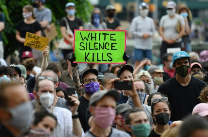 Des manifestants blancs, l'un armé d'une pancarte disant "le silence blanc tue", lors d'une manifestation à Brooklyn le 5 juin 2020