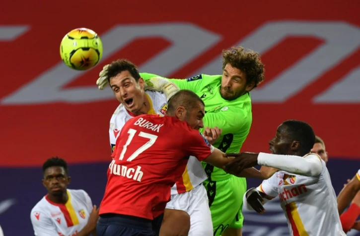 L'attaquant turc Burak Yilmaz, aux prises avec le gardien de but lensois, Jean-Louis Leca, lors du match de L1, le 18 octobre 2020 au stade Pierre-Mauroy