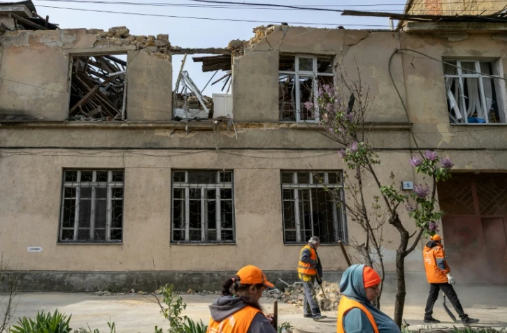 Des employés municipaux nettoient les dégâts causés par une frappe russe sur une école maternelle à Odessa en Ukraine le 30 avril 2026