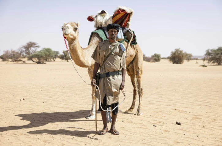 Sidnq, un membre de l'unité du Groupement nomade de la Garde nationale mauritanienne, pose pour un portrait à côté de son dromadaire dans la région de Hodh Ech Chargui (Mauritanie), le 7 avril 2025