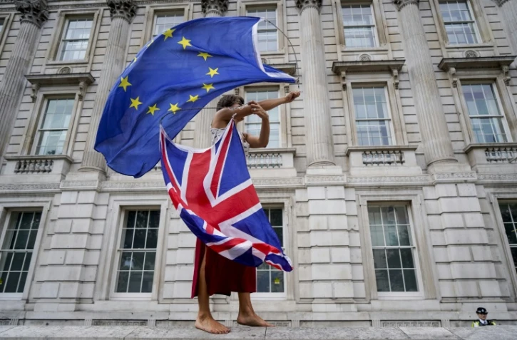 Un manifestant anti-Brexit fait tournoyer des drapeaux européen et britannique lors d'une manifestation à Londres le 31 août 2019