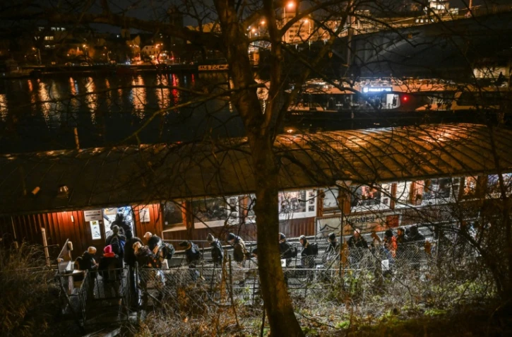 Des personnes font la queue pour passer la nuit sur l'Hermes, une péniche amarrée près de l'un des nombreux ponts qui enjambent la rivière Vltava à Prague, où le nombre de sans-abri connaît une augmentation inquiétante, le 26 janvier 2026
