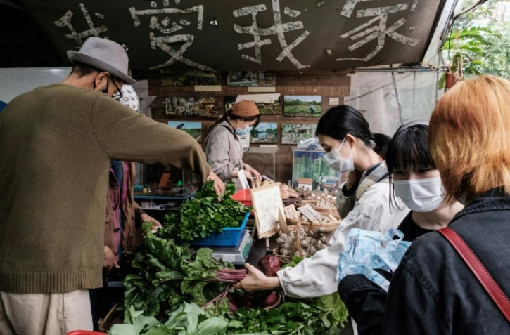 Mandy Tang (centre D), à la tête d'un groupe de pression soutenant les producteurs hongkongais, achète des betteraves produites localement à la ferme communautaire de Mapopo, le 18 mars 2020 à Hong Kong