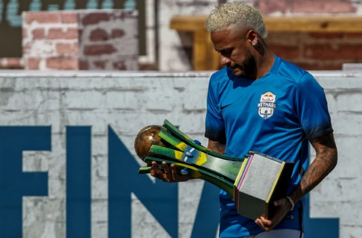Le joueur de football Brésilien Neymar tenant un trophée lors d'un tournoi de football à cinq au bénéfice de sa fondation basée à Praia Grande (sud-est du Brésil), le 13 juillet 2019