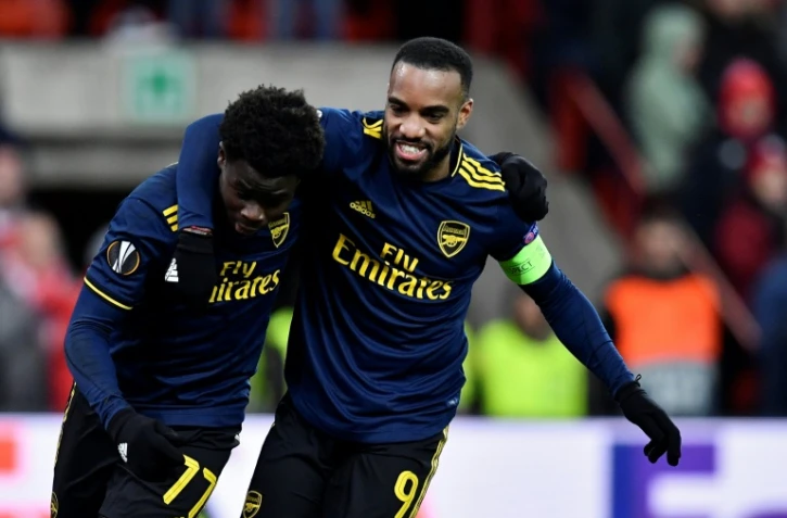 Les attaquants d'Arsenal Bukayo Saka (g) et Alexandre Lacazette heureux après un but du premier sur le terrain du Standard de Liège en Ligue Europa, le 12 décembre 2019