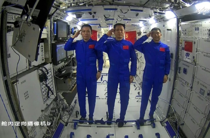 Les astronautes chinois Tang Hongbo (G), Nie Haisheng (C) et Liu Boming (D) saluant depuis la station spatiale chinoise le 23 juin 2021