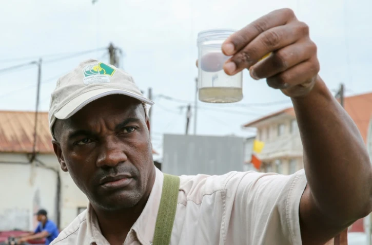 Un employé de la collectivité territoriale de Guyane collecte des larves de moustiques pendant une opération contre le virus du Zika, à Cayenne, le 19 février 2016