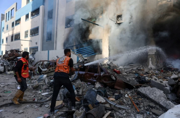Des sauveteurs éteignent les flammes à l'intérieur d'une école de l'ONU transformée en abri après avoir été touchée par une frappe israélienne, dans le quartier de Rimal de la ville de Gaza, dans le nord de la bande de Gaza, le 14 novembre 2024