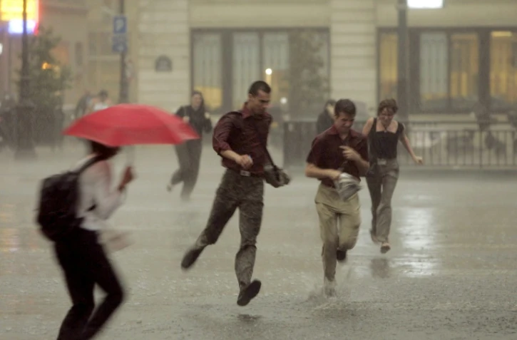 Des personnes courent dans les rues de Paris afin de se mettre à l'abri de la pluie lors d'un orage le 23 juin 2005