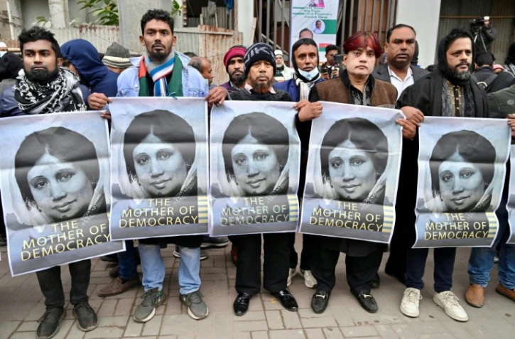 Des partisans de l'ancienne Première ministre du Bangladesh Khaleda Zia brandissent des portraits de la dirigeante décédée, le 30 décembre 2025 à Dacca