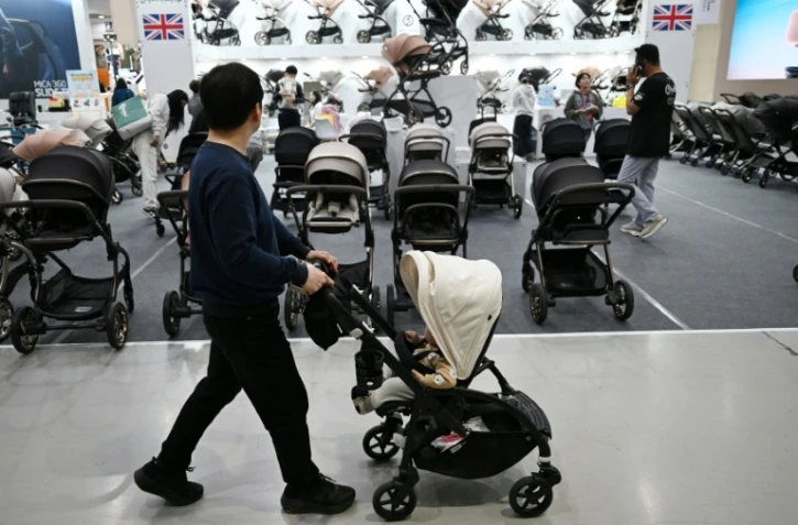 Un homme avec sa poussette dans une allée d'un salon de l'enfant, le 30 avril 2026 à Séoul 