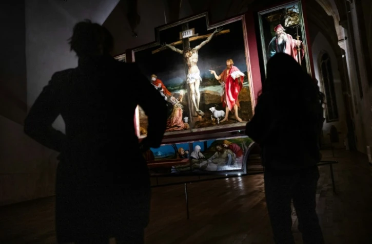 Des visiteurs admirent le retable d'Issenheim lors d'une visite du musée Unterlinden à la lampe torche, le 23 janvier 2024 à Colmar, dans le Haut-Rhin