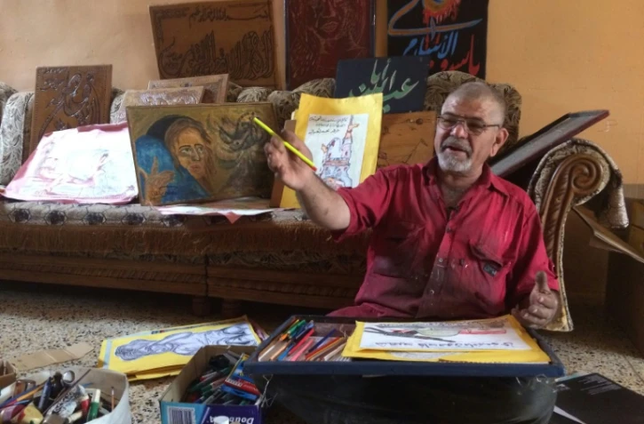 L'Irakien Mostafa montre ses dessins lors d'une interview avec l'AFP, le 23 mai 2017 ) Hamman al-Alil, au sud de Mossoul