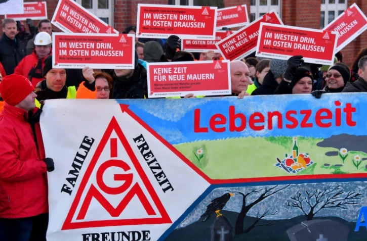 Des ouvriers de l'usine Bombardier brandissent des panneaux au logo du syndicat allemand de la métallurgie IG Metall, à Hennigsdorf prÚs de Berlin (nord-est), le 8 janvier 2018
