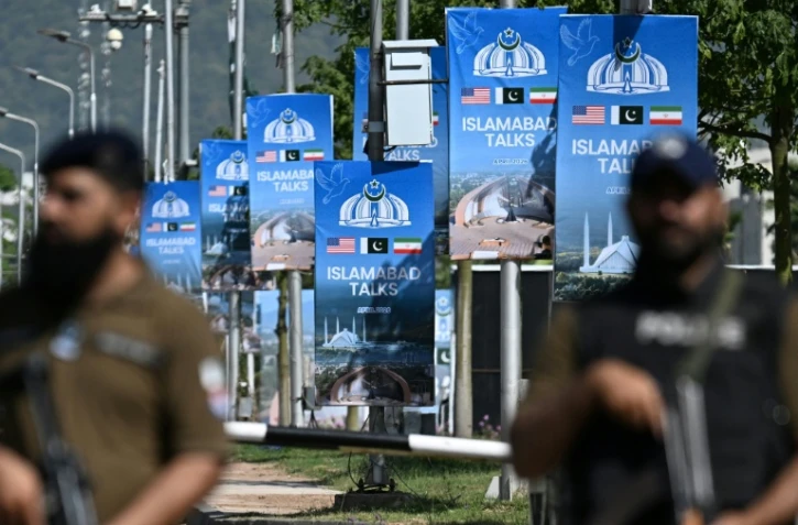 Des membres des forces de sécurité montent la garde le long d'une route temporairement fermée en prévision des pourparlers de paix américano-iranien, le 20 avril 2026 à Islamabad, au Pakistan 