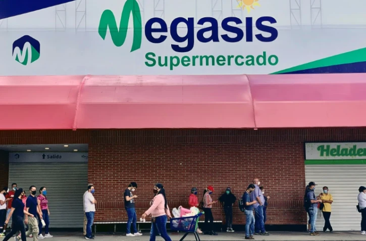 Des clients font la queue devant le supermarché Megasis à Caracas le 31 juillet 2020