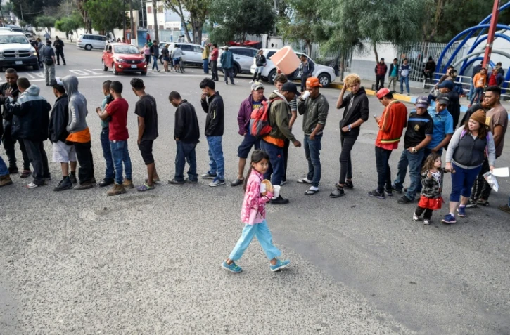 Des migrants d'Amérique centrale essayant de pénéterr aux Etats-Unis font la queue pour une distribution de nourriture à Tijuana au mexique le 15 novembre 2018