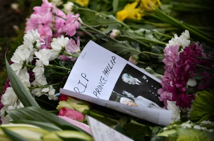 Des fleurs et des messages de condoléance déposés devant le château de Windsor, ouest de Londres, le 11 avril 2021, deux jours après la mort du Prince Philip, époux de la reine Elizabeth II