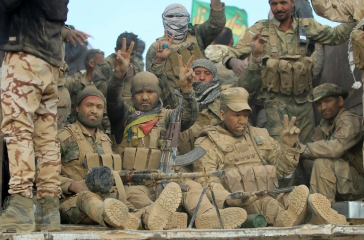 Des combattants chiites de la coalition Hachd al-Chaabi font le signe de la victoire à l'arrivée dans un village au sud de Mossoul, le 31 octobre 2016