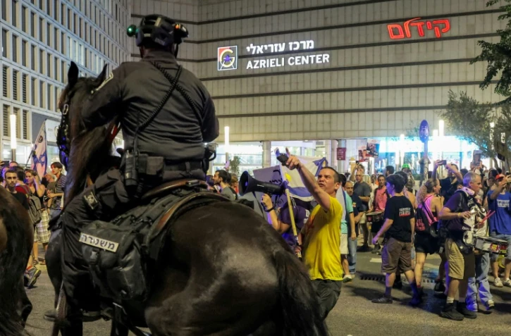 Confrontation entre un policier monté et un manifestant, lors d'une manifestation à Tel-Aviv pour réclamer un accord de cessez-le-feu à Gaza et le retour des otages du 7-Octobre, le 9 août 2025