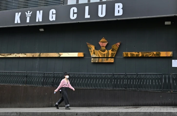 Une femme masquée devant un club de nuit fermé à Séoul, le 10 mai 2020