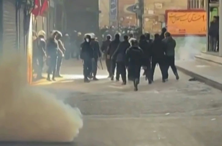 Cette capture d'une video UGC diffusée sur les réseaux sociaux montre des forces de l'ordre iraniennes dispersant des manifestants dans le Grand bazar de Téhéran le 6 janvier 2006