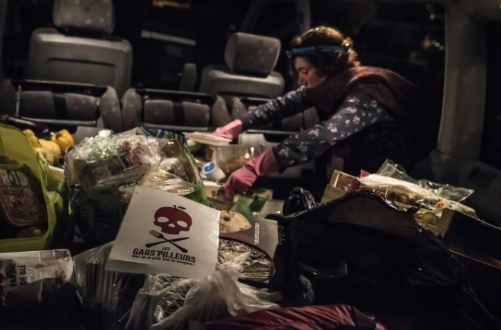 Un membre du mouvement les "Gars'pilleurs" charge un camion avec de la nourriture récoltée dans les poubelles d'un supermarché au sud de Lyon, le 24 septembre 2015