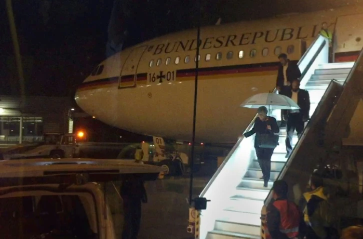 La chancelière allemande Angela Merkel descend de son avion le 29 novembre 2018 au soir à l'aéroport de Cologne après un atterrissage d'urgence