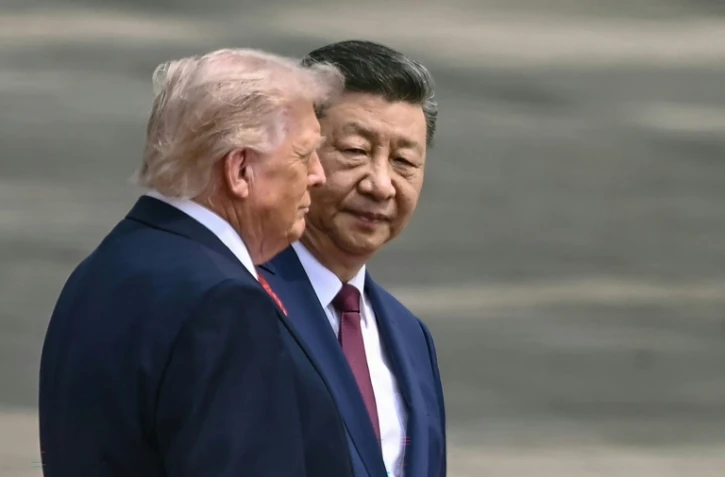 Le président chinois Xi Jinping (d) et le président américain Donald Trump lors d'une cérémonie d'accueil au Grand Palais du Peuple à Pékin, le 14 mai 2026