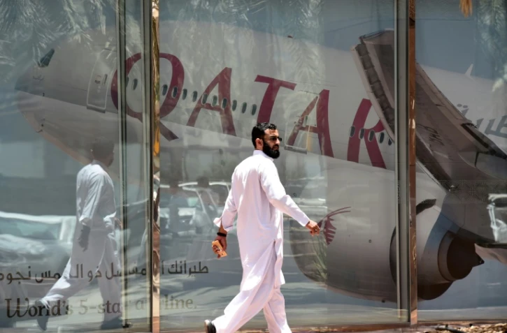 Un homme devant une publicité pour la compagnie aérienne qatarienne "Qatar Airways", à Riyad le 5 juin 2017