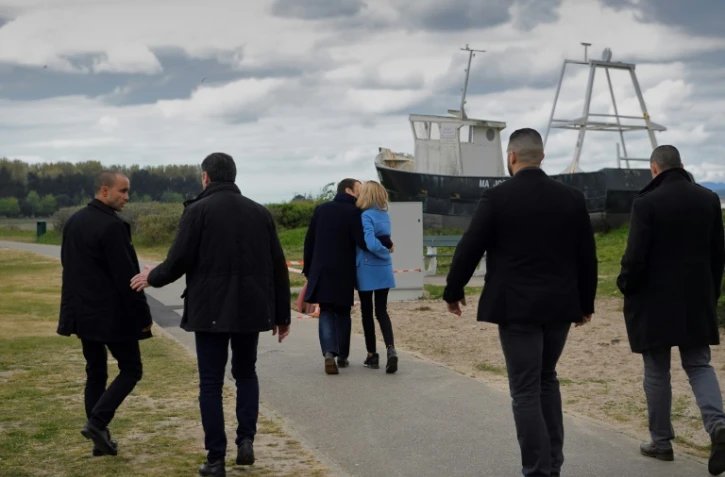Emmanuel Macron et sa femme Brigitte, entourés de gardes du corps, posent pour un photographe de l'AFP au Touquet le 22 avril 2017 à la veille du 1er tour
