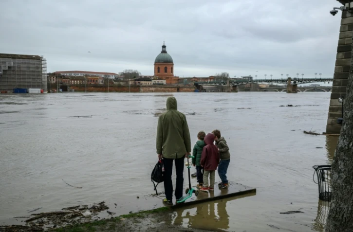 Des personnes observent la Garonne après de fortes pluies, à Toulouse, le 11 février 2026