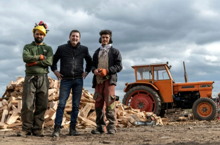 Les Afghans Matiullah Mehrabi (g) et Sherbaz Safizada (d) avec leur employeur Alain Capella, patron d'une scierie familiale, le 24 février 2022 à Aigueperse, dans le Puy-de-Dôme