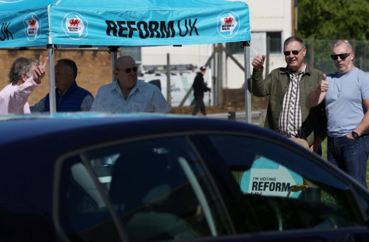 Des militants du parti Reform à Merthyr Tydfil, au Pays de Galles, le 24 avril 2026, pendant la campagne électorale 