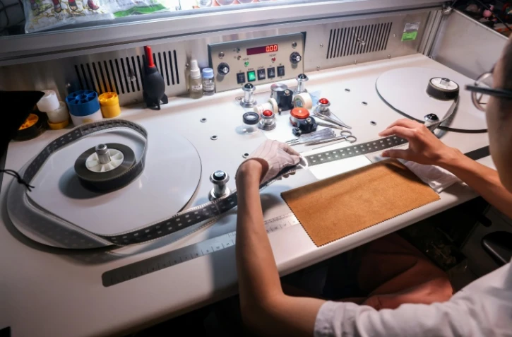 Un technicien inspecte la pellicule d'un vieux film à l'Institut taïwanais du cinéma et de l'audiovisuel (TFAI), le 23 juin 2026 à Taipeï

