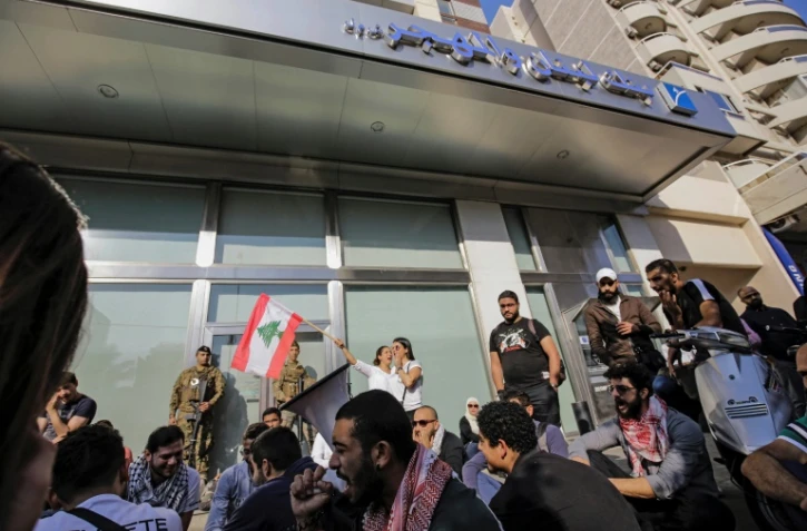 Des manifestants scandent des slogans devant la branche locale de la Banque du Liban, à Tripoli, le 6 novembre 2019