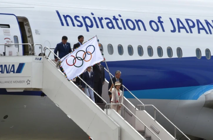 La gouverneure de Tokyo Yuriko Koike exhibe le drapeau du mouvement olympique, en provenance de Rio, à l'aéroport Haneda, le 24 août 2016