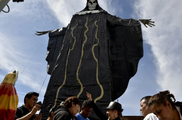 Des dévots de la "Santa Muerte" reçoivent la bénédiction d'Enriqueta Vargas (3e en partant de la droite) également appelée "La Madrina" (la marraine) lors d'une cérémonie à Santa Maria Cuautepec, au Mexique, le 7 février 2016