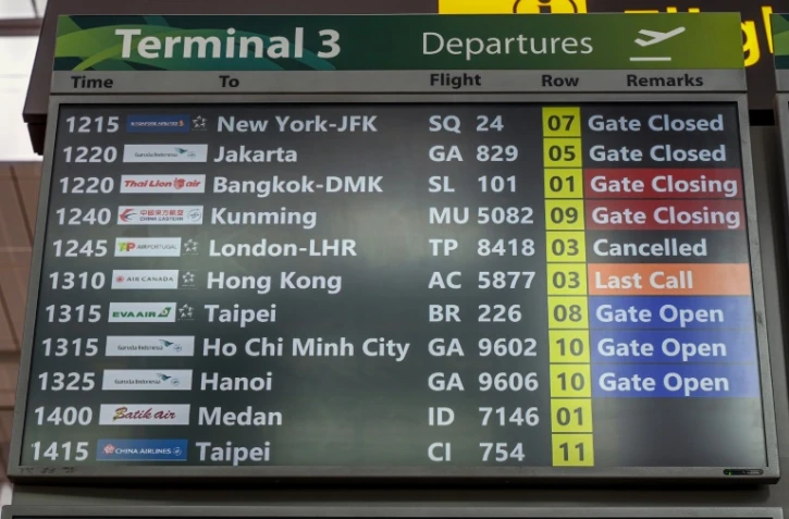 Un tableau d'information indique que le vol TP8418 d'Air Portugal à destination de Londres Heathrow est annulé à l'aéroport Changi de Singapour, le 21 mars 2025