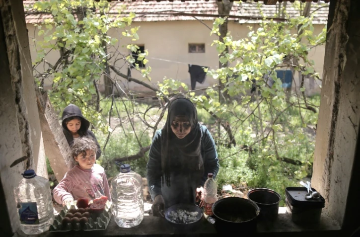 Seror Alhayani, mère irakienne de quatre enfants, prépare un repas dans une maison abandonnée du village serbe de Majdan, qu'ils occupent, près de la frontière avec la Hongrie et la Roumanie, le 21 mai 2021