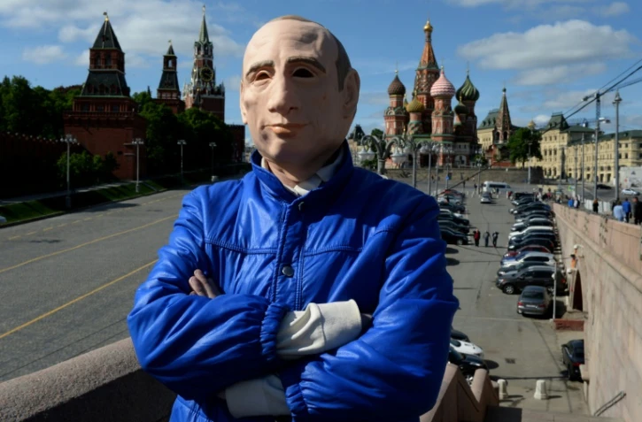 L'artiste russe Roman Roslovtsev porte un masque Ă  l'effigie de Vladimir Poutine, dans le centre de Moscou le 12 mai 2016
