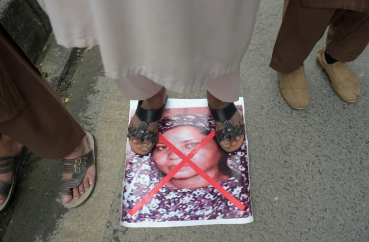 Le portrait de la chrétienne Asia Bibi, accusée de blasphème, et condamnée à mort, est barré d'une croix rouge et piétinée lors d'une manifestation contre son acquittement par la Cour suprême, le 2 novembre 2018 à Islamabad, au Pakistan