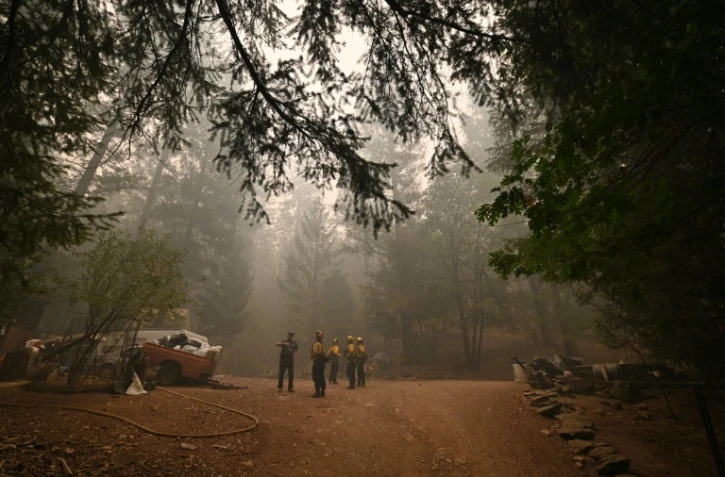 Jon Cappleman avec des pompiers sur son terrain, à Twain, en Californie, le 26 juillet 2021