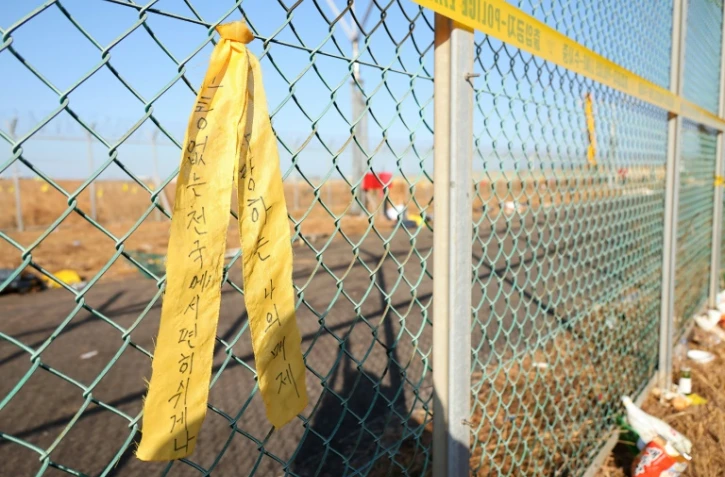 Un message de condoléances accroché sur une grille de l'aéroport de Muan, dans le sud-ouest de la Corée du Sud, le 1er janvier 2025