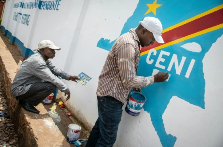Des ouvriers peignent le logo de la Commission électorale nationale indépendante (Céni) à Lubumbashi, en République démocratique du Congo, le 20 décembre 2018.