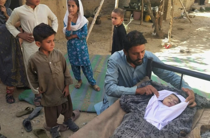 Un père auprès du corps de son fils décédé suite à l'effondrement d'un toit causé par un séisme de magnitude 5,9 dans la région d'Harnai au Pakistan, le 7 octobre 2021